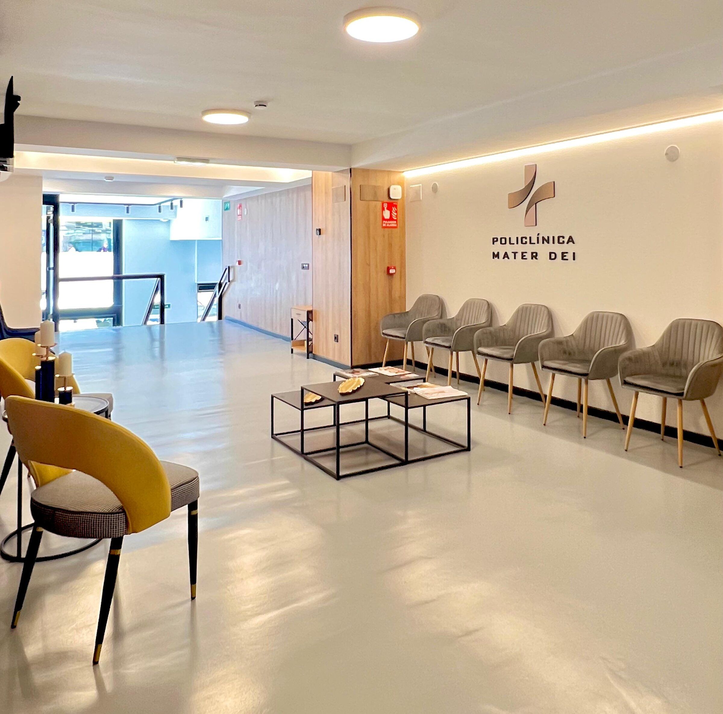 Sala de espera de la segunda planta con sillones, mesas bajas y el logotipo de la clínica